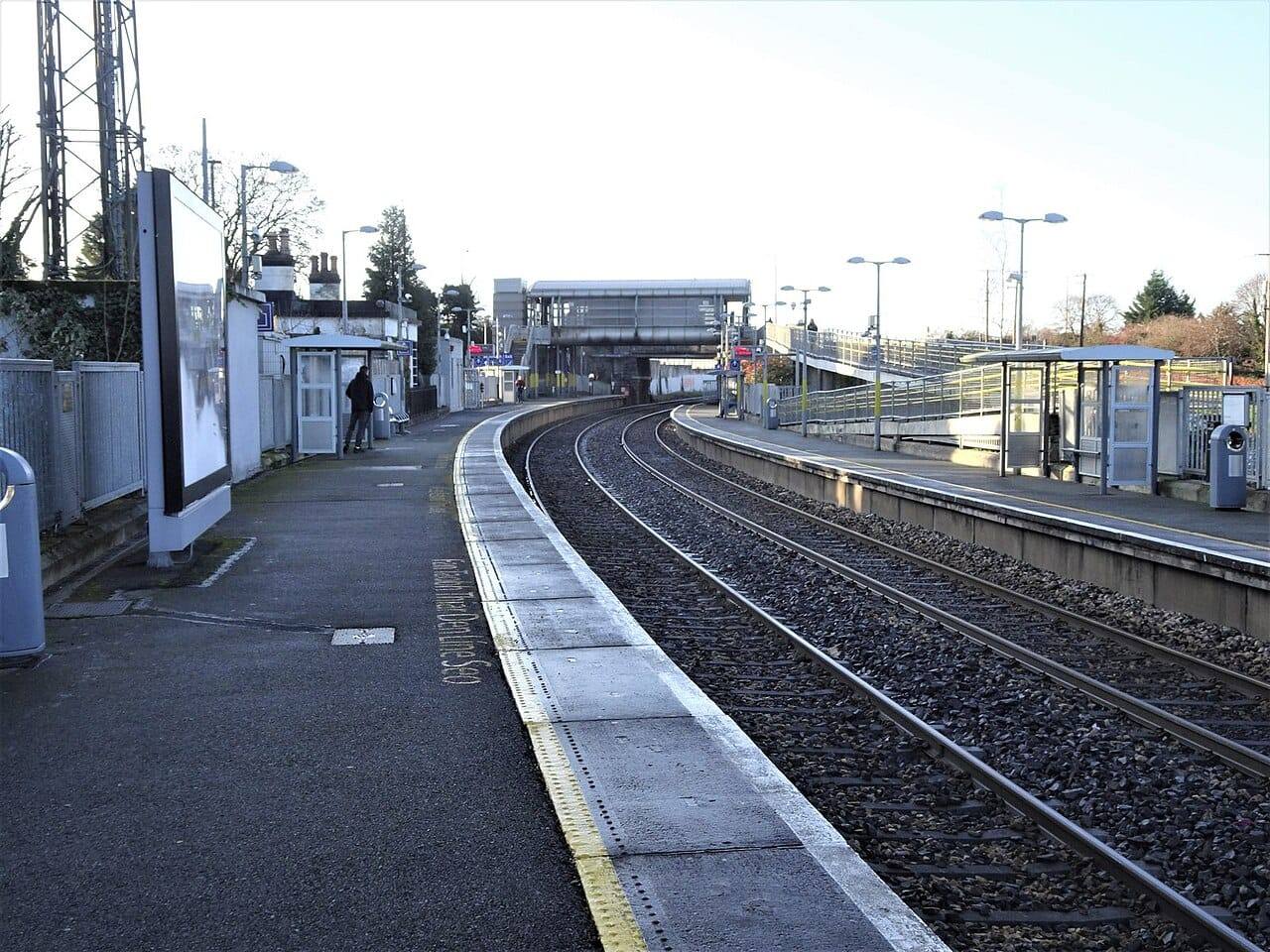 The platforms and curving tracks of Leixlip Louisa Bridge station on a bright winter day, with the footbridge and shelters in the distance.
